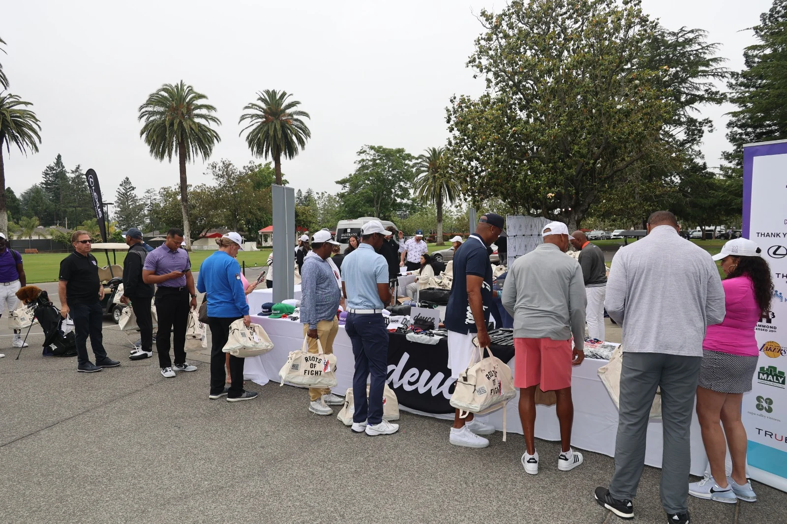 Golfers gathered beside a Deuce event gift table